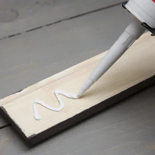 Klebstoffe - putting-Klebstoff auf ein Stück Holz Fußleiste - Stock-Fotografie